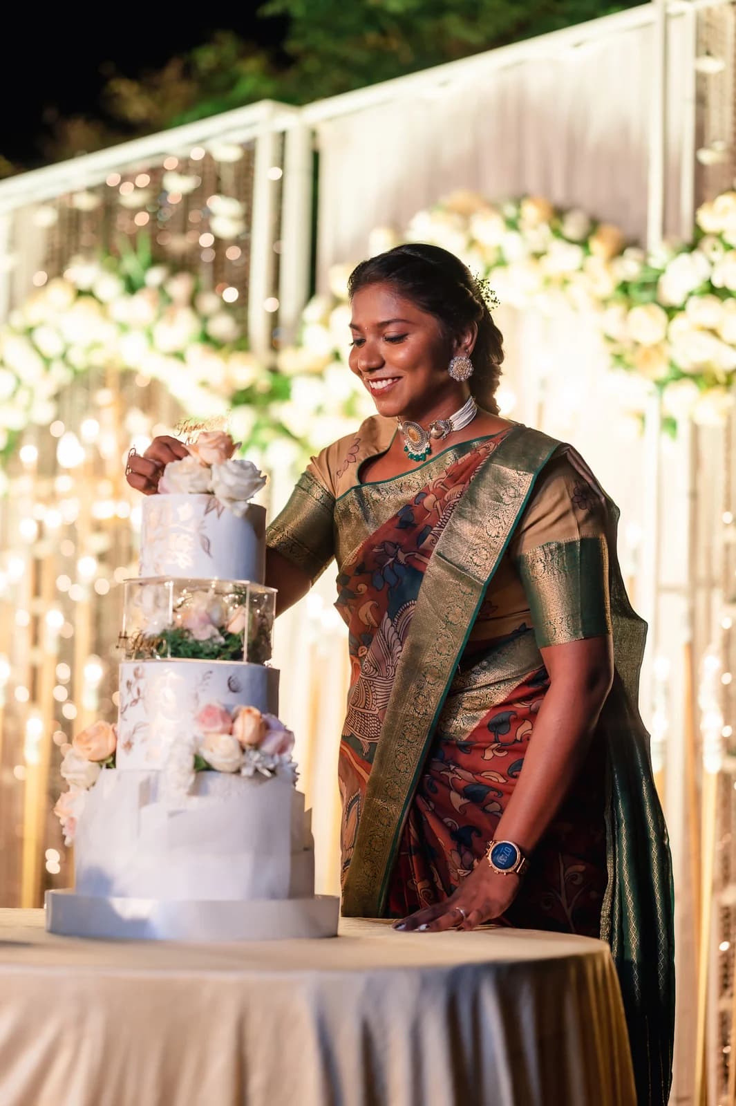 Mridula Ganesan smiling beside a hand-finished celebration cake