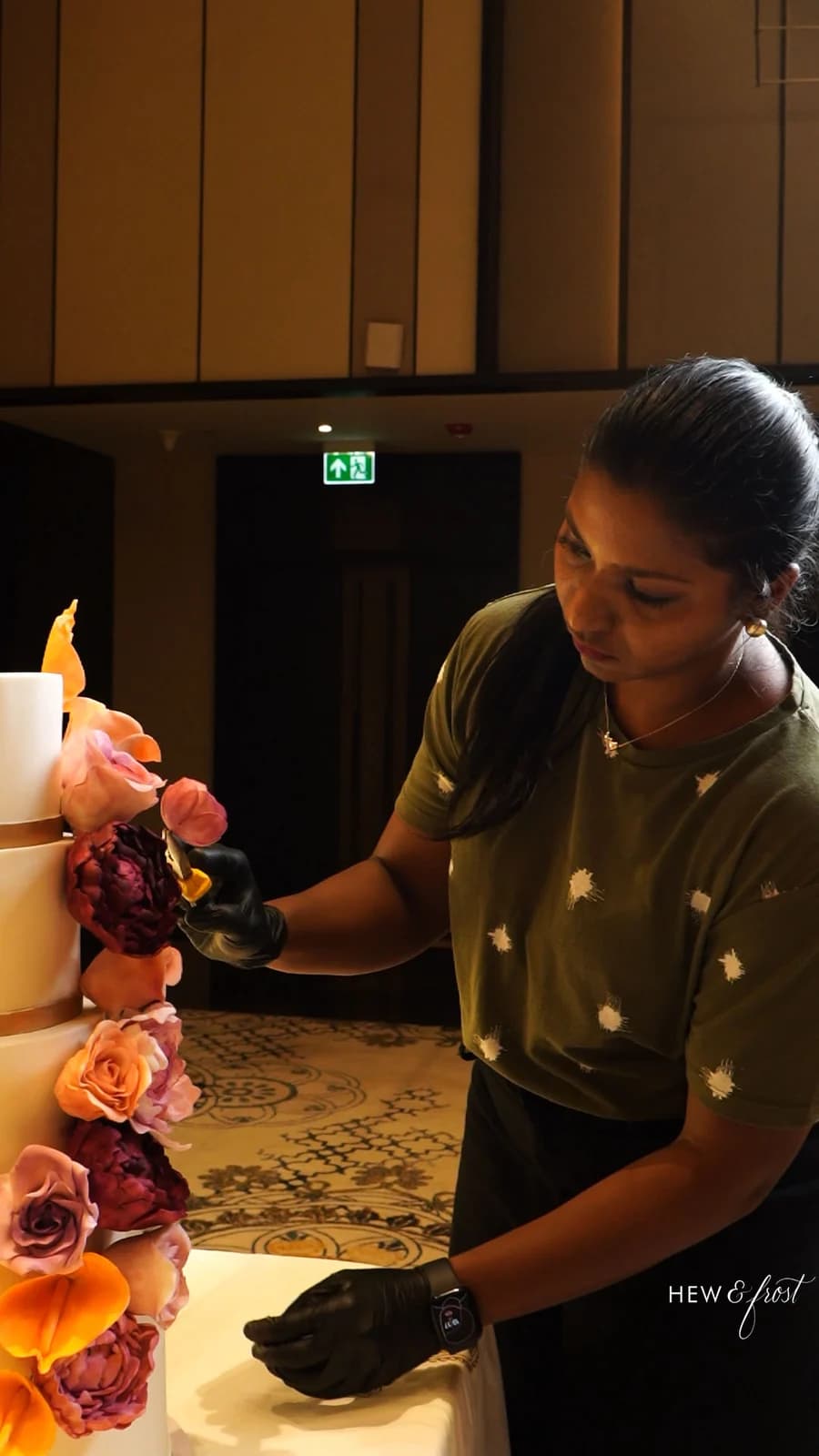 Mridula placing hand-made flowers on a tiered cake